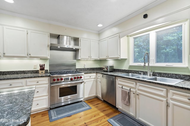 221 Quail Ridge Rd, Wilmington, NC 28409 - kitchen featuring stainless steel appliances, wall chimney range hood, ornamental molding, a sink, and light wood finished floors