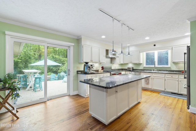 221 Quail Ridge Rd, Wilmington, NC 28409 - kitchen with wall chimney exhaust hood, track lighting, a center island, healthy amount of natural light, and crown molding