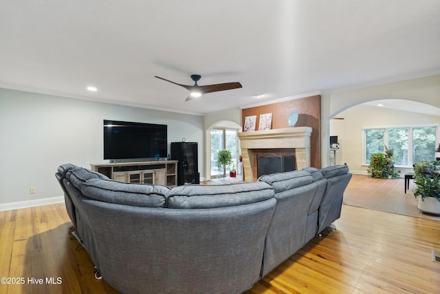 221 Quail Ridge Rd, Wilmington, NC 28409 - living area with arched walkways, a fireplace, a ceiling fan, recessed lighting, and crown molding