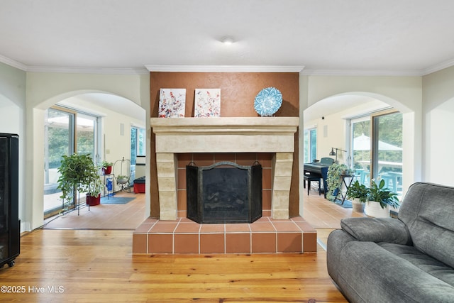 221 Quail Ridge Rd, Wilmington, NC 28409 - living area with light wood-style floors, ornamental molding, a tiled fireplace, and arched walkways
