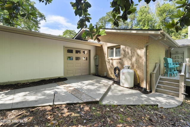221 Quail Ridge Rd, Wilmington, NC 28409 - view of side of home featuring brick siding, an attached garage, concrete driveway, and a deck