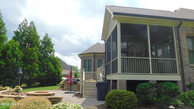 2712 Isaac Dr, Goldsboro, NC 27530 - view of home's exterior with a sunroom, stairway, brick siding, and a shingled roof