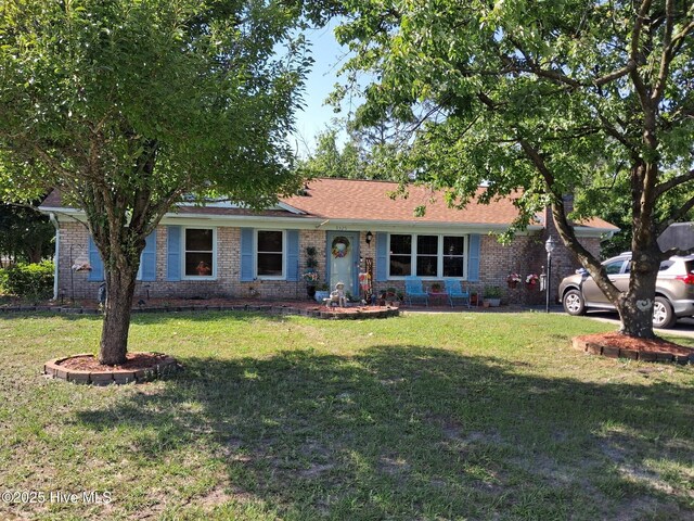 ranch-style home with a front yard and brick siding