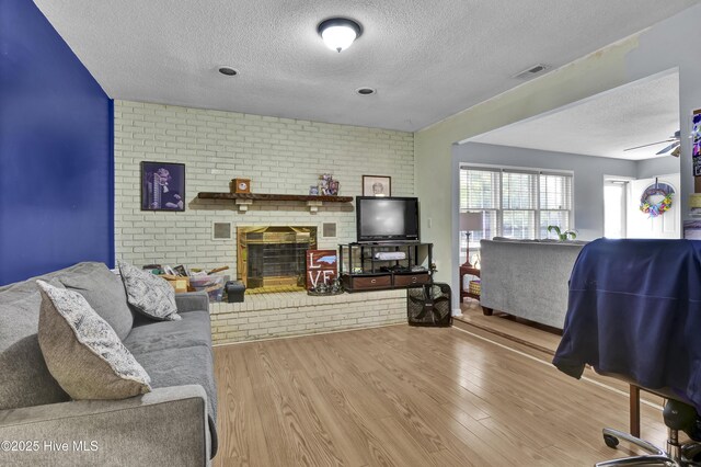 5325 Lord Tennyson Rd, Wilmington, NC 28405 - living area featuring a textured ceiling, wood finished floors, and a brick fireplace