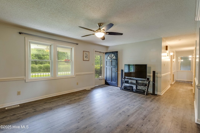 211 Michele Dr, New Bern, NC 28560 - unfurnished living room featuring a textured ceiling, a ceiling fan, wood finished floors, and baseboards
