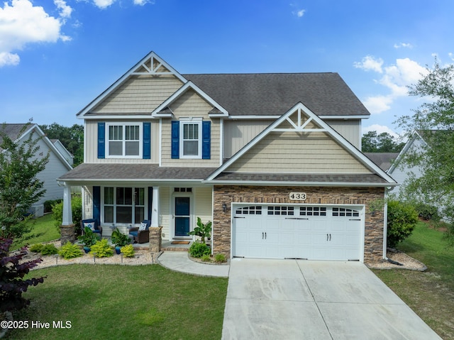 433 Landsdowne Cir, Hampstead, NC 28443 - craftsman house with concrete driveway, a front yard, covered porch, a garage, and stone siding