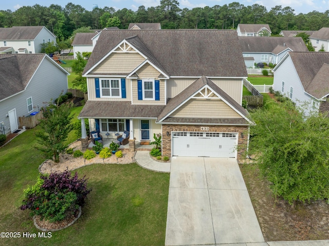 433 Landsdowne Cir, Hampstead, NC 28443 - craftsman-style home featuring a porch, concrete driveway, an attached garage, stone siding, and a residential view