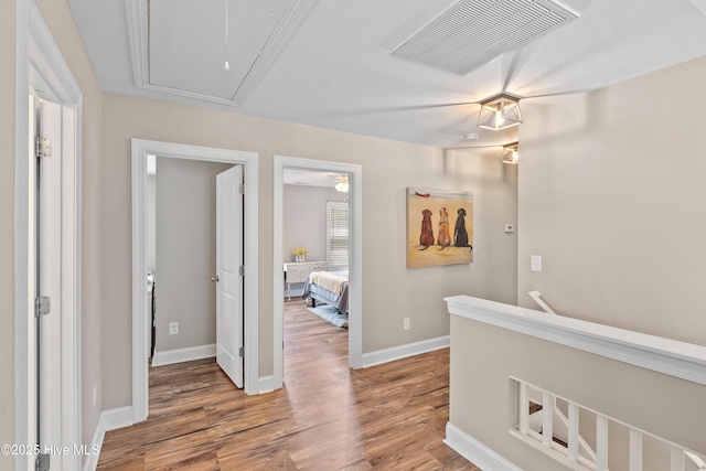 433 Landsdowne Cir, Hampstead, NC 28443 - hallway with attic access, wood finished floors, baseboards, and an upstairs landing