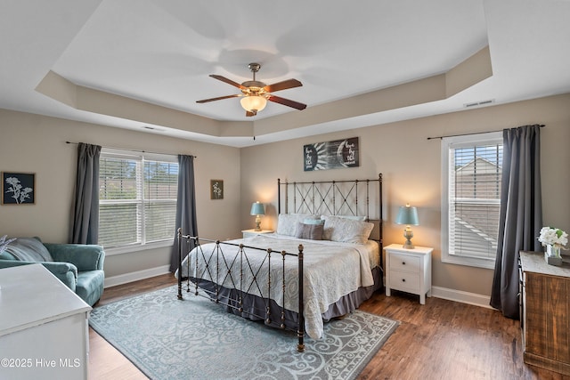 433 Landsdowne Cir, Hampstead, NC 28443 - bedroom featuring a tray ceiling, baseboards, wood finished floors, and ceiling fan
