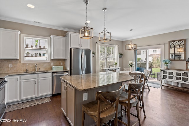 433 Landsdowne Cir, Hampstead, NC 28443 - kitchen with appliances with stainless steel finishes, a sink, light stone countertops, a breakfast bar area, and white cabinets