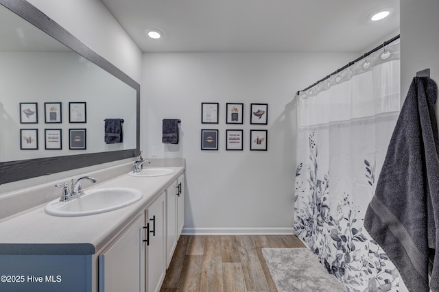 1145 Saint Augustine Dr, Castle Hayne, NC 28429 - bathroom with wood finished floors, double vanity, and baseboards