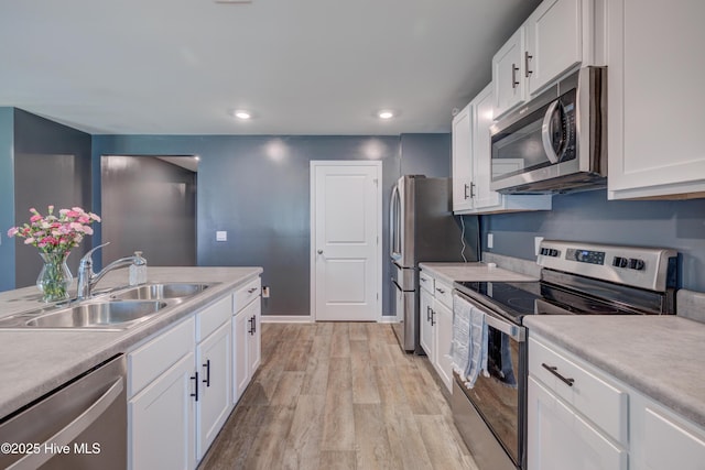 1145 Saint Augustine Dr, Castle Hayne, NC 28429 - kitchen with appliances with stainless steel finishes, a sink, light wood-style floors, light countertops, and recessed lighting