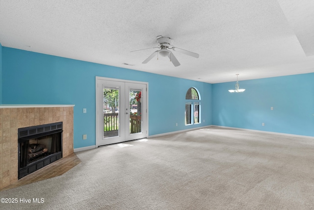 935 Birch Creek Dr, Wilmington, NC 28403 - unfurnished living room featuring a tile fireplace, carpet flooring, a chandelier, ceiling fan, and a textured ceiling