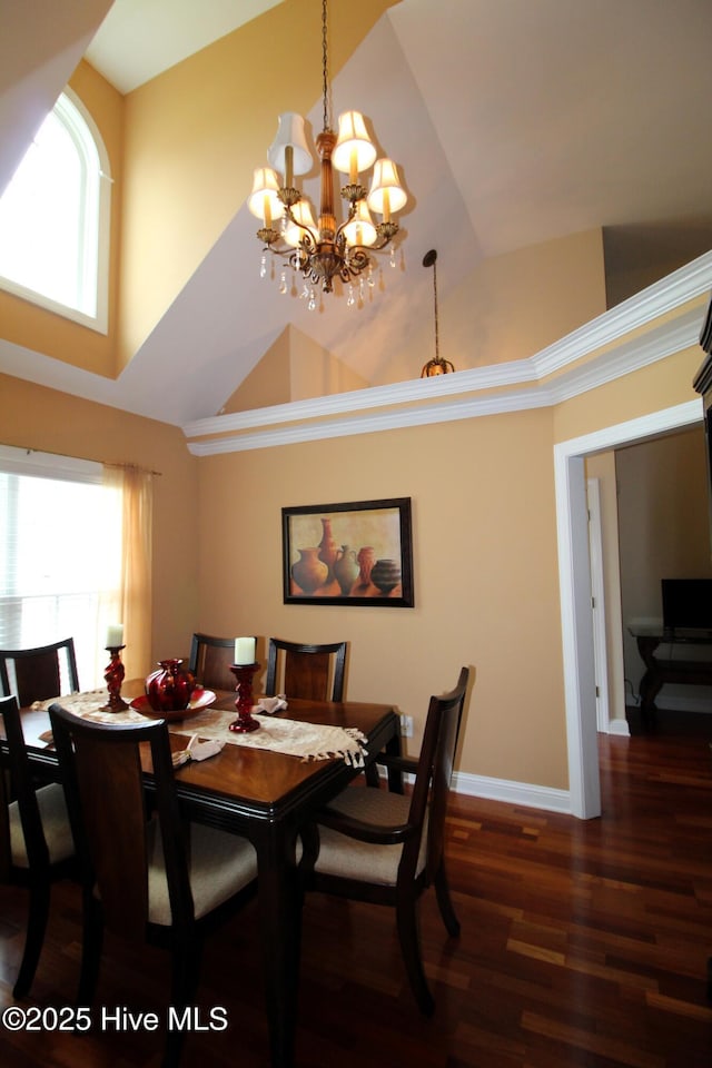dining area with a chandelier, wood finished floors, baseboards, and high vaulted ceiling