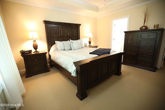 bedroom with light colored carpet, ornamental molding, and a tray ceiling