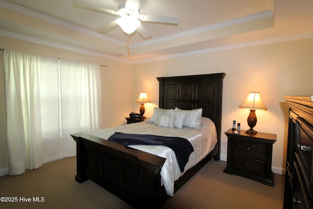 carpeted bedroom featuring a raised ceiling, crown molding, ceiling fan, and baseboards