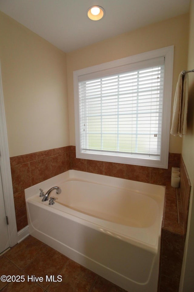 full bath featuring healthy amount of natural light, a bath, tile patterned flooring, and recessed lighting