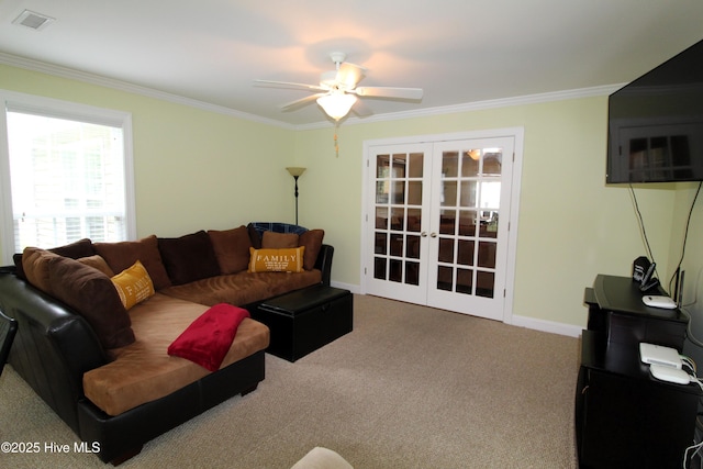 carpeted living area with french doors, ornamental molding, a ceiling fan, and baseboards