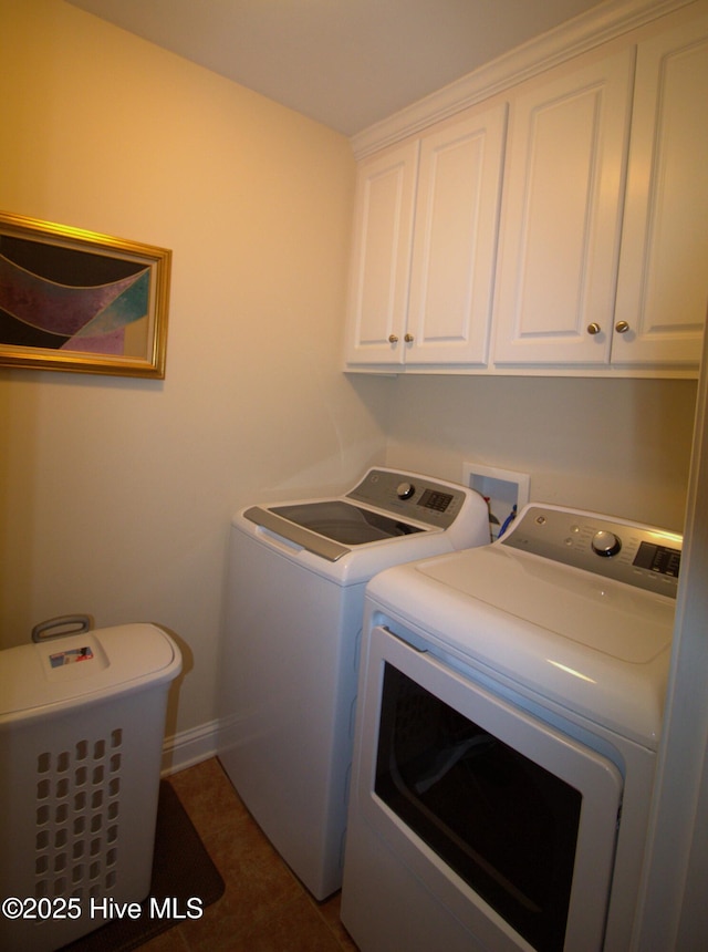 washroom with washer and dryer, cabinet space, and baseboards