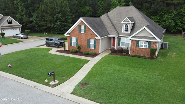 traditional-style home with brick siding, a front yard, and a wooded view