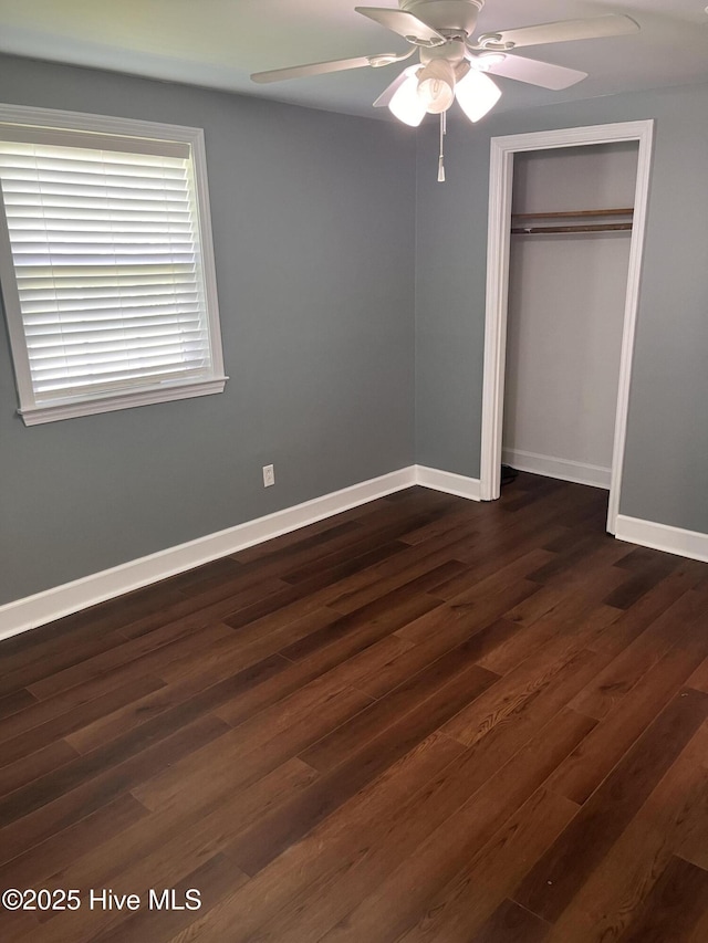 527 Chicora St, Grimesland, NC 27837 - unfurnished bedroom with dark wood-style flooring, a closet, baseboards, and a ceiling fan