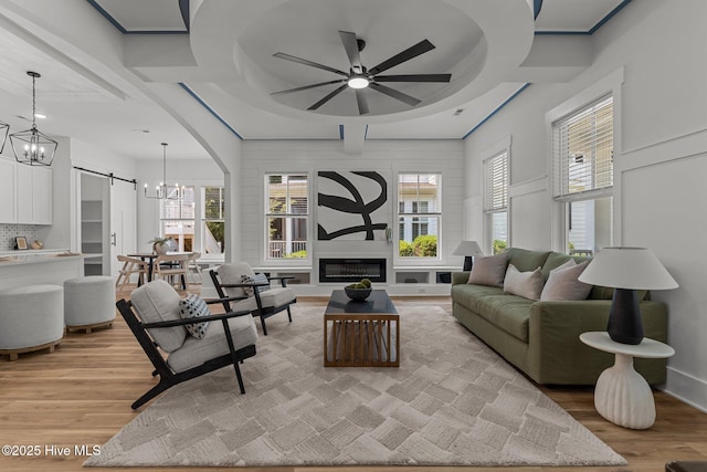 9213 Rivendell Pl SW, Calabash, NC 28467 - living area with a chandelier, light wood finished floors, ceiling fan, coffered ceiling, and plenty of natural light