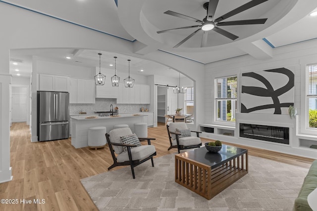 9213 Rivendell Pl SW, Calabash, NC 28467 - living area featuring a ceiling fan, light wood-style floors, coffered ceiling, arched walkways, and recessed lighting