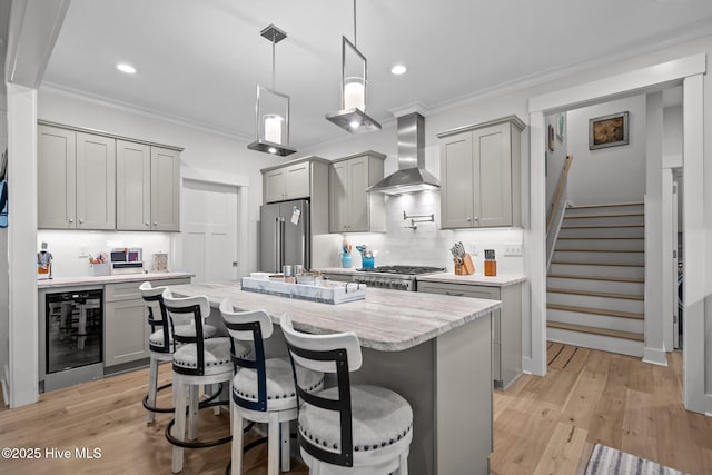 kitchen with high end fridge, beverage cooler, gray cabinetry, wall chimney range hood, and tasteful backsplash