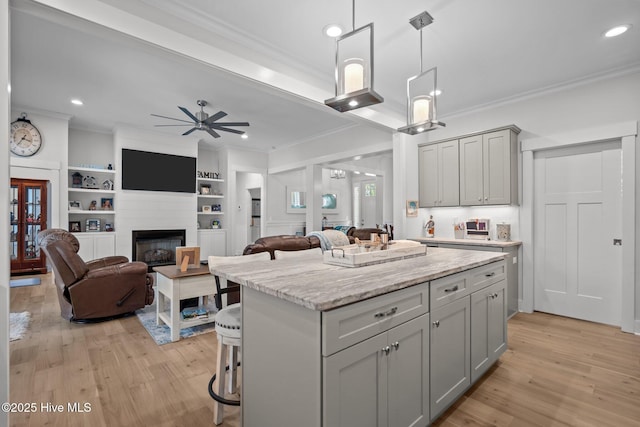 kitchen featuring crown molding, gray cabinetry, recessed lighting, a center island, and ceiling fan