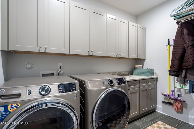 clothes washing area featuring cabinet space and separate washer and dryer