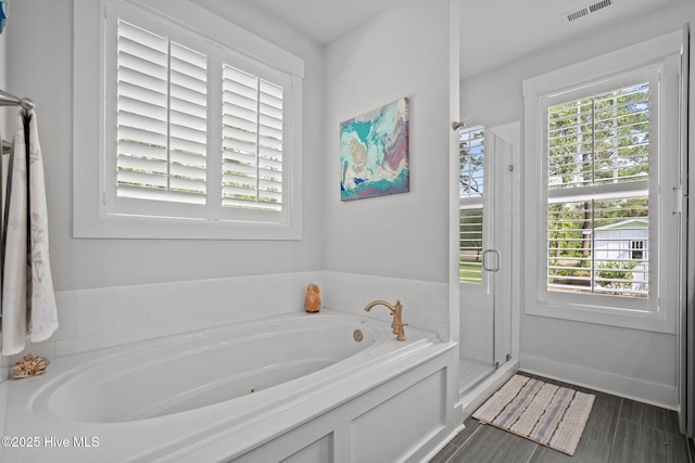 full bath with a shower stall and a garden tub