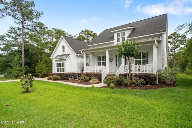 view of front of property with board and batten siding, covered porch, a front yard, and roof with shingles