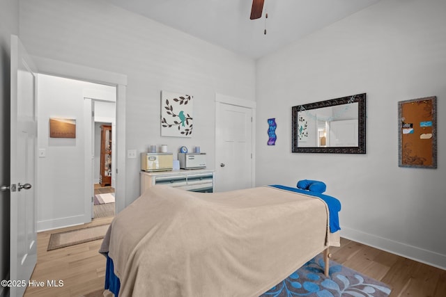 bedroom featuring light wood-type flooring, baseboards, and ceiling fan