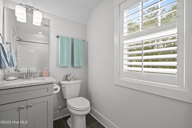 bathroom with plenty of natural light, toilet, baseboards, and vanity