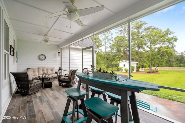 sunroom / solarium with ceiling fan, an outdoor living space, and healthy amount of natural light