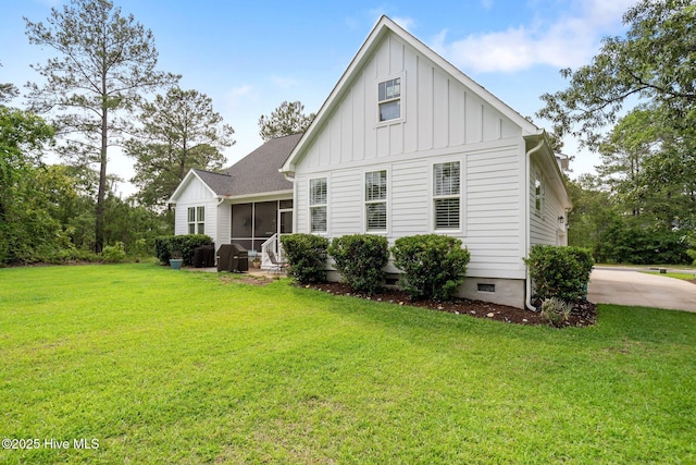 back of property with board and batten siding, a yard, a sunroom, and crawl space