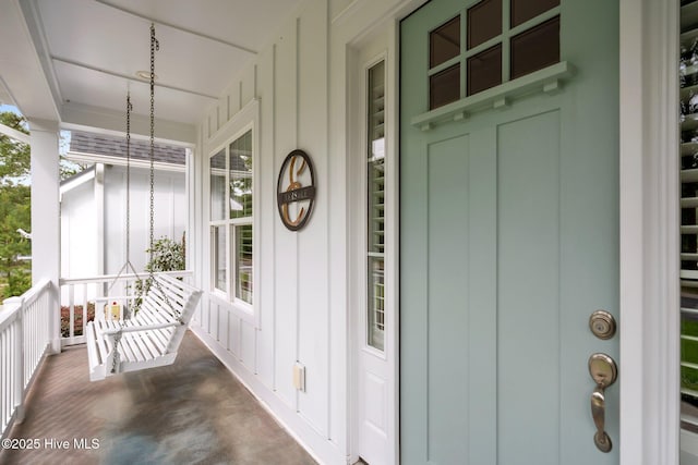 doorway to property featuring covered porch and board and batten siding