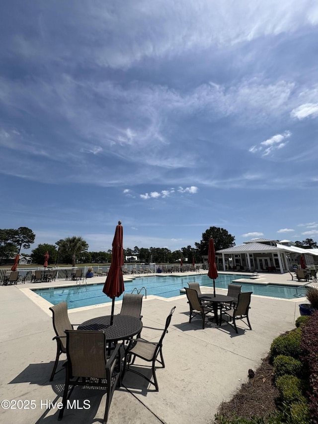 community pool featuring a patio area and fence