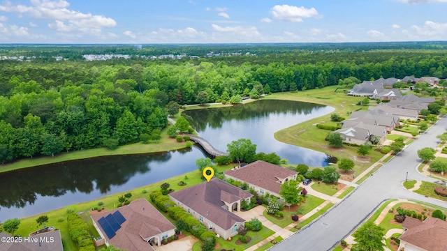 aerial perspective of suburban area featuring a large body of water and a heavily wooded area
