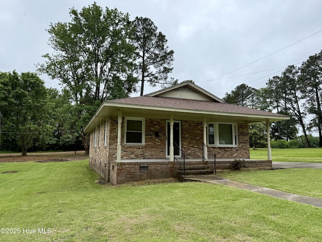 208 W Gray St, Windsor, NC 27983 - view of front of house featuring crawl space, brick siding, a front yard, a porch, and roof with shingles