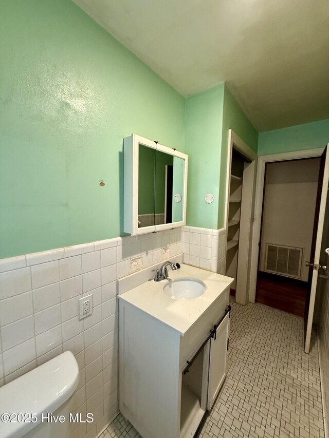 208 W Gray St, Windsor, NC 27983 - bathroom with tile walls, toilet, vanity, wainscoting, and tile patterned floors
