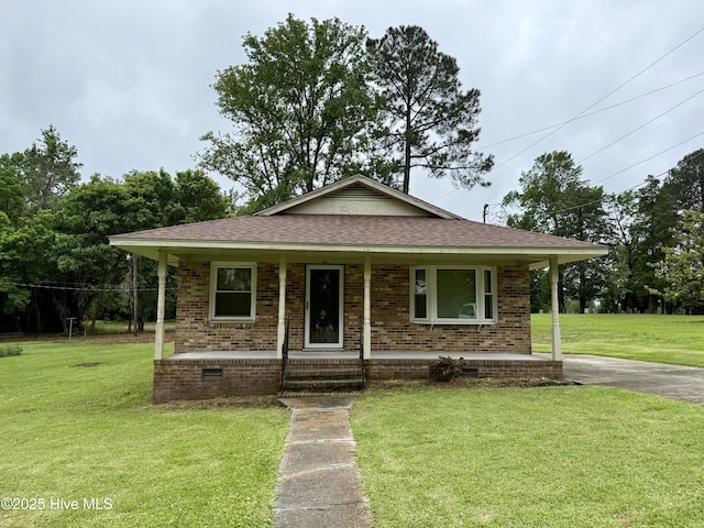 208 W Gray St, Windsor, NC 27983 - view of front of house with a porch, a shingled roof, a front yard, and brick siding
