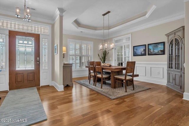 1013 Dowling Ct, Leland, NC 28451 - dining space featuring a chandelier, wood finished floors, ornamental molding, and a tray ceiling