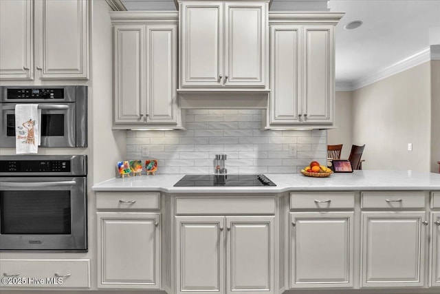 1013 Dowling Ct, Leland, NC 28451 - kitchen featuring black electric stovetop, crown molding, light countertops, decorative backsplash, and white cabinets