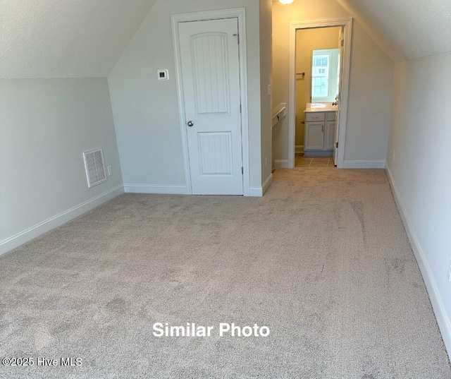 100 Sloth Ln, Jacksonville, NC 28546 - additional living space featuring vaulted ceiling, light carpet, baseboards, and a textured ceiling