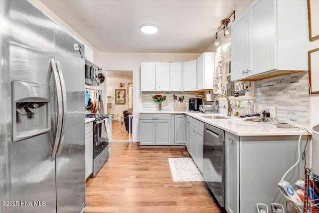 1605 E Holly St, Goldsboro, NC 27530 - kitchen with stainless steel appliances, a sink, light countertops, light wood-style flooring, and backsplash