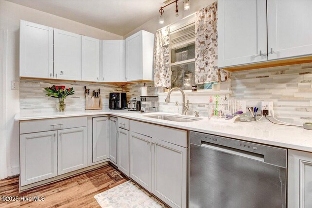 1605 E Holly St, Goldsboro, NC 27530 - kitchen with dishwasher, a sink, decorative backsplash, light countertops, and light wood-style flooring