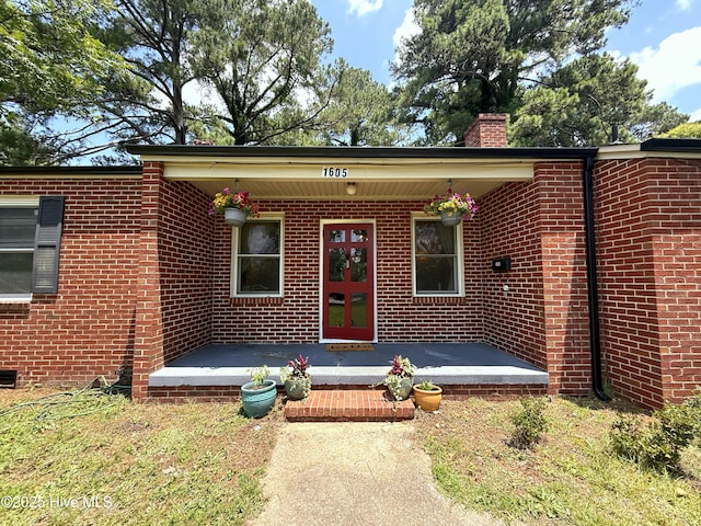 1605 E Holly St, Goldsboro, NC 27530 - view of exterior entry featuring a chimney and brick siding