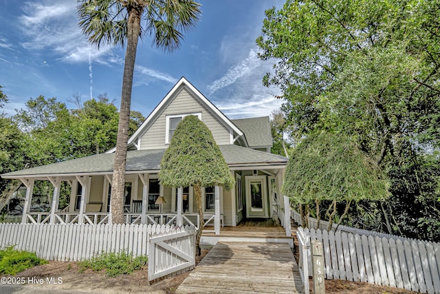 659 Wash Woods Way, Bald Head Island, NC 28461 - view of front facade featuring a shingled roof, a porch, and a fenced front yard
