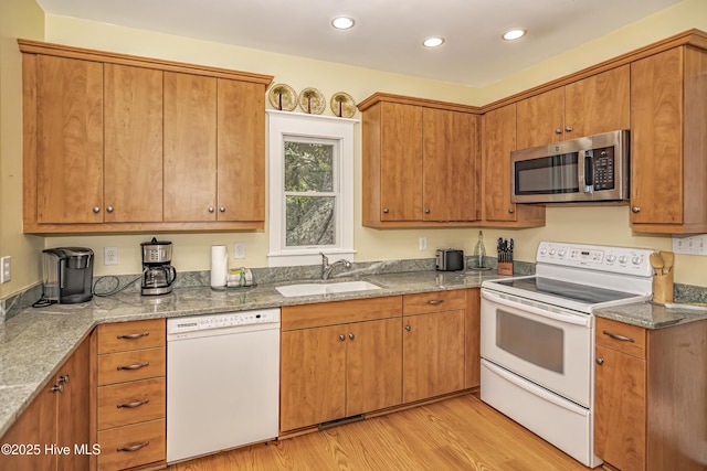 659 Wash Woods Way, Bald Head Island, NC 28461 - kitchen with white appliances, a sink, light wood finished floors, brown cabinetry, and recessed lighting